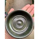 DDR BBQ Supply handmade ceramic shave bowl with a dark green and black speckled glaze held in a palm