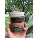 DDR BBQ Supply handmade ceramic shave bowls in white, black, brown, and green stacked in a hand outdoors.