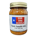 A 16 oz pint glass jar of DDR BBQ Supply Chipotle Tomatillo Salsa (Medium) with a gold lid. The Texas flag label displays product details. The chunky, smoky salsa contains visible seeds and spices for bold flavor.