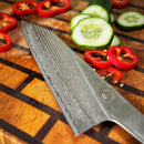 DDR BBQ Supply Spaceman Knives Calypso Kiritsuke with Damascus steel blade on a wooden board with sliced vegetables