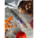 The Spaceman Knives Gravity Series Utility Knife, featuring a Damascus-pattern AUS-10 steel blade and a purple-brown handle, rests on a textured surface with sliced carrots, tomato, red onion, cutting board, and white cloth.