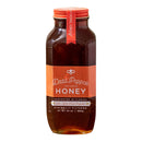 Honey Truck Co Raw Datil Pepper Infused Honey, a 24 oz clear glass jar with a red lid, features minimalistic orange and white text on its label. Harvested in Florida by Honey Truck Co, this honey blends raw honey with the distinctive heat of locally grown Datil peppers, creating a rich amber hue and an unforgettable flavor.