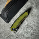 DDR BBQ Supply Spaceman Knives Galatea folding pocket knife with an olive green G10 handle and black nylon carry case.