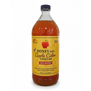 A clear 32 oz (946 ml) glass bottle labeled Guenther Apiary Apple Cider Vinegar with Honey & “Mother” features a red apple and honeycomb design. This organic vinegar is 100% raw, unfiltered, and from Guenther Apiary.