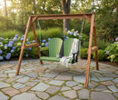 The Kanyon Living Poly Lumber 4′ Adirondack Swing in lime green and black sits on a stone patio with a striped blanket and mug, surrounded by blooming hydrangeas—an inviting outdoor furniture piece for any garden retreat.