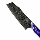 A close-up of the Spaceman Knives Gravity Series Nakiri, featuring a black Damascus-patterned blade with a decorative emblem and a glossy purple handle, set against a white background.