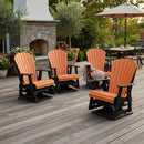 Four Kanyon Living Adirondack Poly Glider Swivel Chairs in orange & black are arranged in a circle on a wooden patio near an outdoor fireplace, surrounded by potted plants. These Amish-made chairs create an inviting backyard scene.