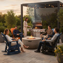 Five adults relax on the patio, chatting in Kanyon Living Adirondack Poly Glider Swivel Chairs (Orange & Black) by Kanyon Living. One grills while others unwind, enjoying greenery and string lights on a pleasant evening.