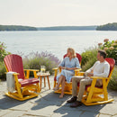 A smiling woman and man relax by a lake in Kanyon Living Adirondack Poly Glider Swivel Chairs in Red & Yellow, with lemonade on a small table between them. Surrounded by flowers, the patio offers peaceful water views—ideal for outdoor enjoyment.