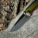DDR BBQ Supply Spaceman Knives Galatea folding knife with olive green G10 handle and stainless steel blade on stone