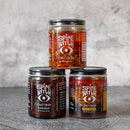 DDR BBQ Supply Spice Witch chili crisp trio featuring Original, Black Garlic, and Spicy Honey jars in avocado oil.