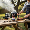 DDR BBQ Supply Sweet Bourbon Glaze bottle on a wooden table with a pitmaster brushing ribs at a backyard grill