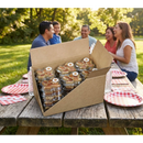 DDR BBQ Supply bulk case of 30 individually packaged Texas pecan cakes on a picnic table at an outdoor gathering.