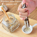 A hand uses the DDR BBQ Supply Thumb Grinder by DDR BBQ Supply to grind pepper into a small white dish, with a jar of peppercorns and wooden spoon on a wooden board. Text reads: DDR BBQ Supply Thumb Grinders stainless steel manual pepper mill.