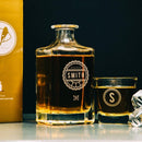 A square glass decanter engraved with Reserve Smith and a matching glass featuring a large S monogram, both filled with amber whiskey, are examples of Whiskey Glasses: Medalist by Swanky Badger.