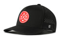 The Haka Hat Detroit Hockey Performance 5-Panel Hat | DET X Flexfit Snapback from Haka Hat is a black baseball cap featuring a red and white circular patch with crossed hockey sticks and the letters DET on the front. This Detroit hockey hat also includes small ventilation holes on the side, an H logo, and combines classic style with modern comfort. It is designed as a performance 5-panel hat with a Flexfit snapback closure for an adjustable fit.
