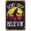 The Lone Star Art "Don't Stop Believing Big Foot" metal sign features a Sasquatch silhouette, sunset, and trees with the phrase “DON’T STOP BELIEVIN’”—a perfect cabin decor or gift for Bigfoot fans.