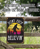 The Lone Star Art "Don't Stop Believing Big Foot" Metal Sign features Bigfoot at sunset with "DONT STOP BELIEVIN." Beautiful, affordable, and safe for indoor or outdoor use—perfect for cabin decor or a unique Sasquatch gift!.