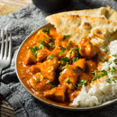 A plate of chicken tikka masala with white rice and naan bread, garnished with The Spice Lab Whole Leaf Cilantro, sits on a gray cloth napkin next to a silver fork.