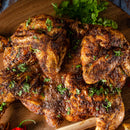 Succulent, spiced roasted chicken garnished with chopped herbs on a wooden board, finished with a bold sprinkle of The Spice Lab Scotch Bonnet Sea Salt for authentic Caribbean-inspired flavor. Fresh parsley in the background enhances the vibrant presentation of this dish featuring The Spice Lab’s signature seasoning.