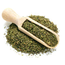 A wooden scoop filled with The Spice Lab Savory Whole Leaf 1 lb—dried, chopped green herbs ideal for BBQ seasoning or foodservice herb applications—rests atop a small pile of the same savory whole leaf herbs from The Spice Lab, all isolated on a white background.