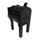 A black, barrel-shaped outdoor pellet grill fitted with four Green Mountain Grills Trek Extension Legs (GMG-4029), a side handle, chimney vent, control panel, sleek design, and compatibility with Trek grill accessories.