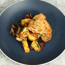 Succulent roasted chicken thigh paired with golden potatoes, mushrooms, and herbs on a dark plate, finished with The Spice Lab Mediterranean Citrus Seasoning.