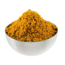 A metal bowl filled with a mound of The Spice Lab Organic Indian Curry Powder, isolated on a white background.