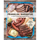 The cover of Franklin Barbecue: A Meat-Smoking Manifesto [A Cookbook] - Hardcover, from Books by splitShops, displays an enticing tray laden with beautifully smoked brisket, ribs, sausage, coleslaw, pickles, potato salad, and bread—a true testament to expert brisket-cooking from acclaimed pitmaster Aaron Franklin and co-author Jordan Mackay.