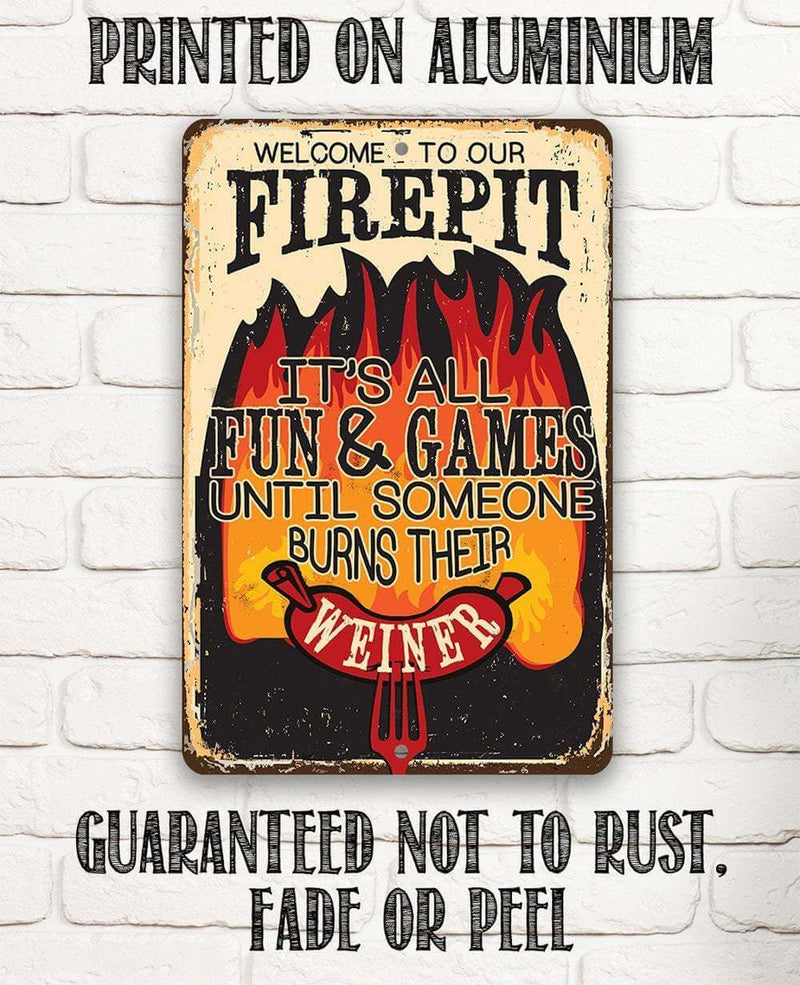 Metal sign with humorous text about a fire pit on a white brick wall background.