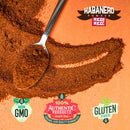 A spoon with habanero powder on an orange background, surrounded by Non GMO, 100% Authentic Products, and Gluten Free labels, plus Rico Rico Chile Powder 6 Pack Bundle at the top—perfect for fans of authentic Mexican spices or anyone looking to add a kick to their chile powder bundle with flavorful options like Ancho, Arbol, Chipotle, Guajillo, Habanero, and Pasilla.