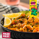 A bowl of shrimp with chopped vegetables, garnished with lemon wedges and chives, sprinkled with Rico Rico Habanero Chile Powder Shaker for that hot spice kick. The image features the Rico Rico logo and a colorful banner reading "Authentic Mexican Flavor for all your meals!.