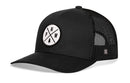 The Haka Hat PNW Trucker Hat is a black snapback with a mesh back and round front patch showing "P N W" and a tree icon. Part of the HAKA signature trucker collection, it features a white background.