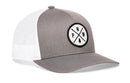 The Haka Hat PNW Trucker Hat is a gray and white snapback featuring a black and white circular PNW patch with a pine tree design.