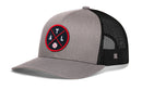The Haka Hat Atlanta Trucker Hat is a gray and black mesh snapback featuring a round front patch with crossed lines, the letters ATL, and a baseball in the center. The back of this Atlanta trucker hat is black mesh.