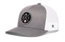 The Haka Hat Chicago Trucker Hat is a silver snapback with a mesh back, featuring a round black patch with crossed lines, the letters CHI, and a baseball graphic—a classic trucker style from Haka Hat.