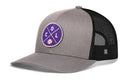 The Haka Hat Colorado Trucker Hat (COL X Baseball Snapback) features a gray and black design inspired by Denver, with a round purple “COL” patch and baseball icon, mesh back, snapback closure, and slightly curved brim.