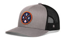 The Haka Hat Houston Trucker Hat | HOU X Baseball Snapback by Haka Hat features a gray and black mesh design, a round patch with crossed orange lines, HOU, and a baseball icon. It has a snapback closure, curved brim, and structured front panel.