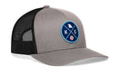 The Haka Hat Kansas City Trucker Hat features gray and black mesh, a blue circular patch with KC, a baseball icon, map outline, and crossed lines on front, all in a comfort-fit snapback design.