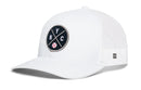 The Haka Hat New York Trucker Hat features a white front, mesh back, and a circular black patch with intersecting N, Y, C lines and a red baseball at the bottom center.