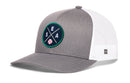The Haka Hat Seattle Trucker Hat | SEA X Baseball Snapback by Haka Hat is a gray and white mesh-back cap with an embroidered front patch featuring crossed lines, the letters S, E, A, and a small baseball.