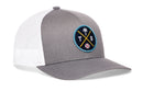 The Haka Hat Tampa Bay Trucker Hat is a gray and white snapback with mesh back, featuring a front round patch with palm tree, baseball, and crossed T and B.