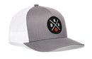 The Haka Hat Brooklyn Trucker Hat is a gray and white mesh snapback with a round black patch featuring bold white BKN letters and an orange basketball icon on the front.