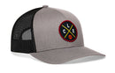 The Haka Hat Cleveland Trucker Hat features a gray and black design with mesh back, a front patch showing crossed yellow lines, white C, L, and E letters, and an orange basketball. Style: CLE X Basketball Snapback by Haka Hat.