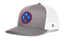 The Haka Hat Detroit Trucker Hat is a gray and white snapback with mesh back, comfort-fit sweatband, and front round blue patch featuring DET lettering, red/blue lines, and an orange basketball. Brand: Haka Hat.