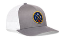 The Haka Hat Indiana Trucker Hat | IND X Basketball Snapback features a gray and white design, mesh back, and a front patch with blue "I N D" letters, crossed yellow lines, and a small basketball at the bottom.