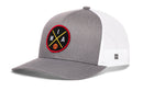 The Haka Hat Miami Trucker Hat features gray and white mesh panels, a round black patch with yellow crossed lines, 'MIA,' an orange basketball icon on the front, and a classic snapback closure.