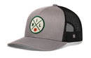 The Haka Hat Milwaukee Trucker Hat | MIL X Basketball Snapback features a gray and black design with a round patch showing green "MIL" letters and a small basketball, plus a curved brim and structured crown for classic style.