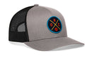 The Haka Hat Oklahoma City Trucker Hat features a gray and black design, mesh back, and blue front patch with crossed yellow lines, OKC letters, and an orange basketball.