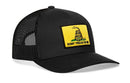 The Haka Hat Dont Tread On Me Trucker Hat is a black mesh snapback featuring a yellow patch with a coiled rattlesnake and DONT TREAD ON ME, inspired by the iconic Gadsden Flag design.